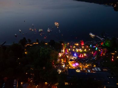 Luftaufnahme auf den Kurpark und das Zwischenahner Meer während der Lichternacht. Dabei leuchten mehrere Lichtobjekte bunt auf.