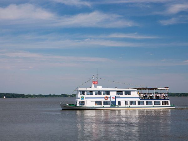 Ein Schiff der Weissen Flotte fährt bei Sonnenschein vollbesetzt über das Zwischenahner Meer.