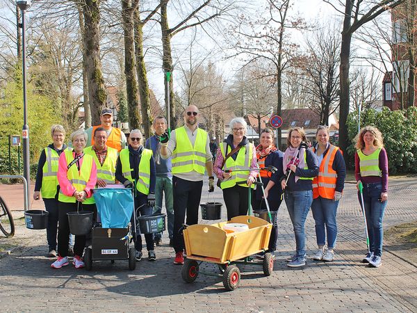 Gruppe von 13 Personen in Warnwesten mit Eimern, Greifzangen und Wagen bei einer Aufräumaktion in Bad Zwischenahn.