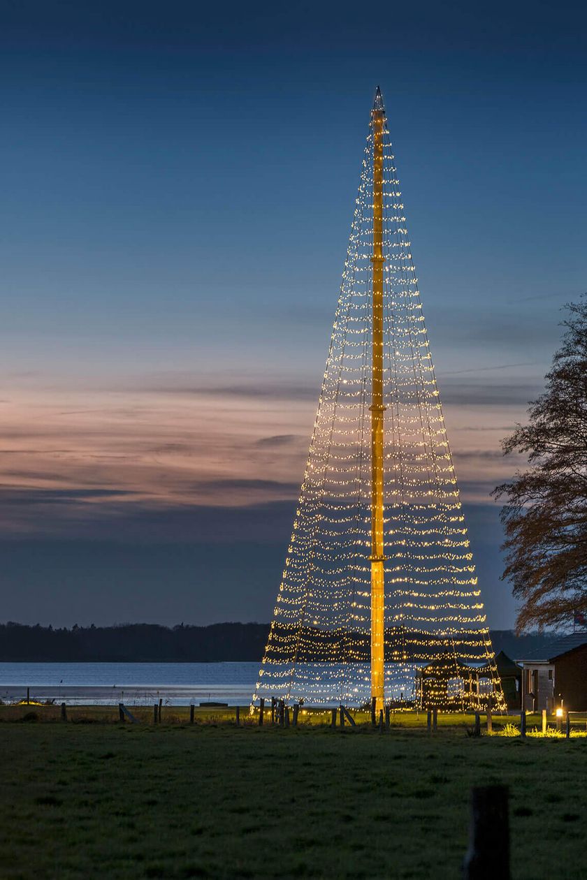 Beleuchteter XXL-Weihnachtsbaum aus Metall vor dem Zwischenahner Meer am Jagdhaus Eiden bei winterlicher Atmosphäre.