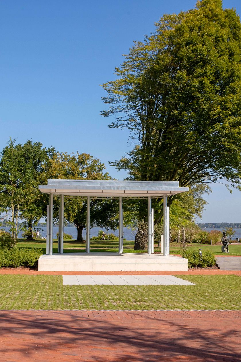 Freilichtbühne im Kurpark ohne Bestuhlung - im Hintergrund grüne Wiese, Bäume und das Zwischenahner Meer.