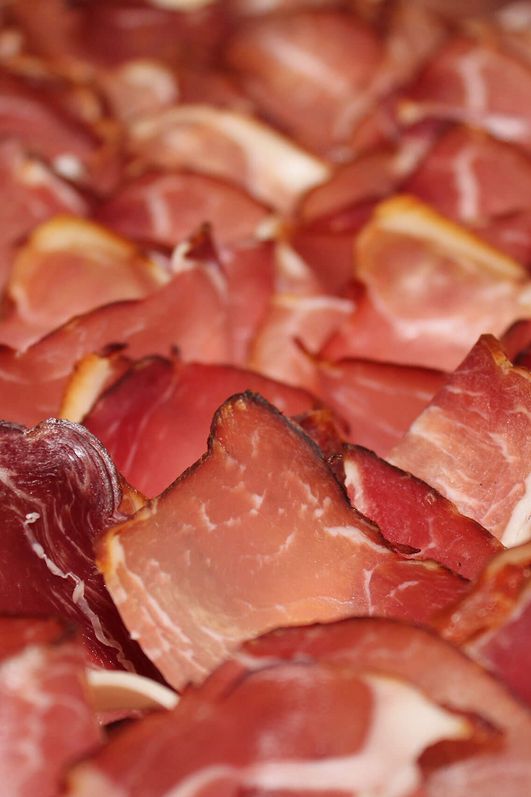 Mehrere Schinken-Häppchen auf einem Brett.